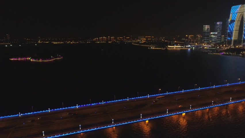 Aerial tilt view on the bridge in the modern city, panoramic view on the bridge with illumination. Aerial view traffic at night on bridge over river.