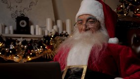 Close up modern smiling Santa Claus greets talks to children online webcam laptop video call. Positive Santa Claus wishes merry Christmas remote computer virtual connection. Happy New Year holidays