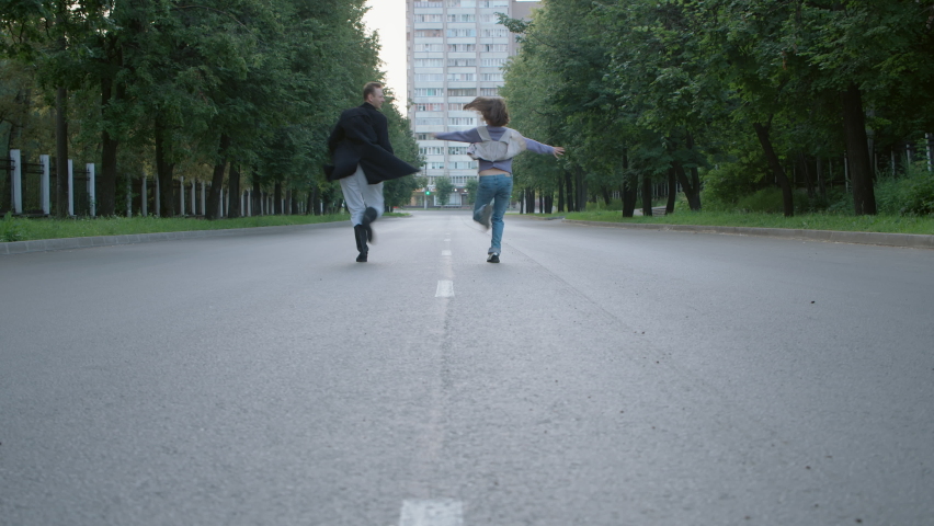 Shooting of happy running couple in early empty morning
