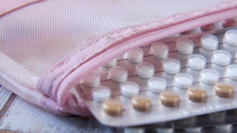 birth control pills on wooden background, close up 