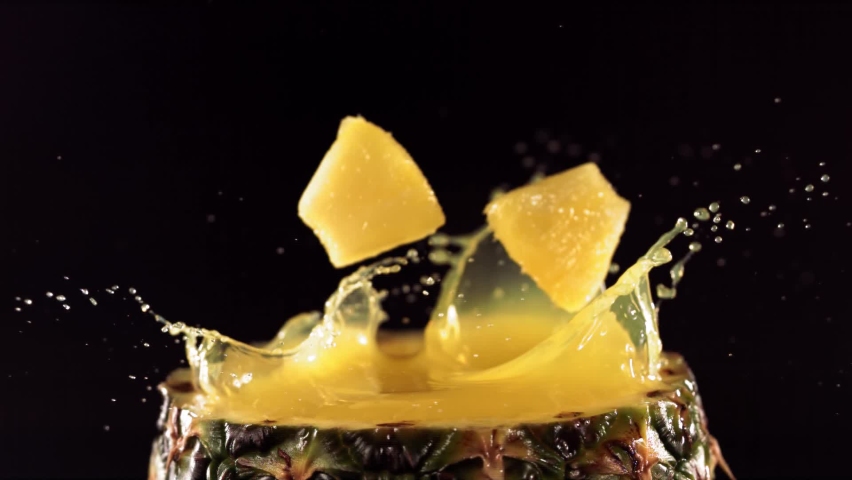 Pineapple pieces falling on the surface of half pineapple in slow motion. | Shutterstock HD Video #1083292198