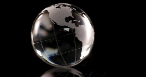 Glass globe with world map spinning on black background 4k movie