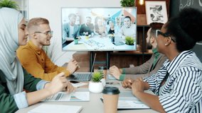 Creative business team are talking to multi-ethnic group of colleagues during video call at work. Cooperation and corporate communication concept. - Powered by Shutterstock - Get 15% off with code: PIKWIZARD15