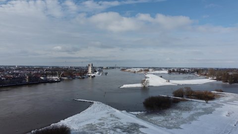 High water level on the snowy floodplains of the river IJssel in the city of Kampen in Overijssel, The Netherlands. Aerial drone point of view.