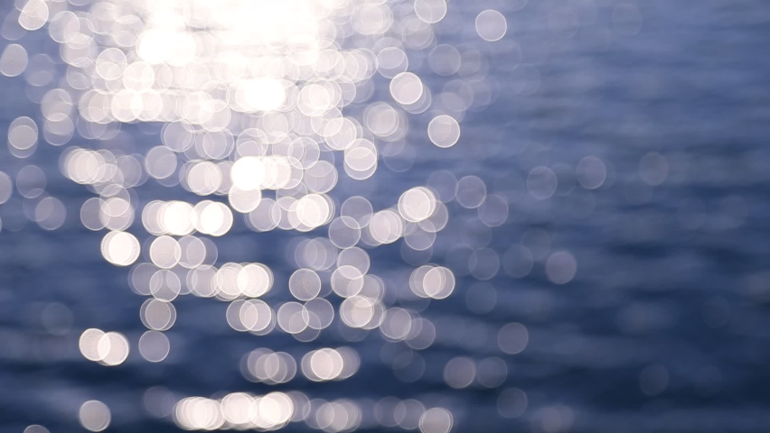 Abstract motion of the sunrise sea, shimmering water defocused background, bokeh effect
