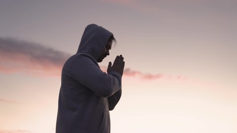 man praying on a pink sky background, believe in good good, ask for help, dream looking up, motivation inspiration outdoors, woman thinks meditating, wanderlust concept, heavenly light