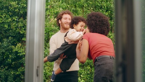 Loving Mixed Race Family Playing with Adorable Baby Boy at Modern Home, Hanging in the Garden. Cheerful Mother and Father Nurturing a Child. Concept of Childhood, New Life, Parenthood.