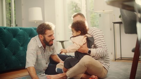 Loving LGBTQ Family Playing with Toys with Adorable Baby Boy at Home on Living Room Floor. Cheerful Gay Couple Nurturing a Child. Concept of Diverse Childhood, New Life, Parenthood.