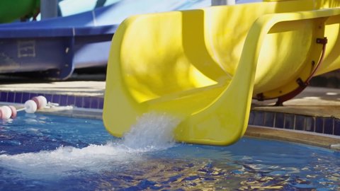 time-lapse. water drains from the yellow slide in the water park.. entertainment for children in the pool. extreme and fun rides. 
