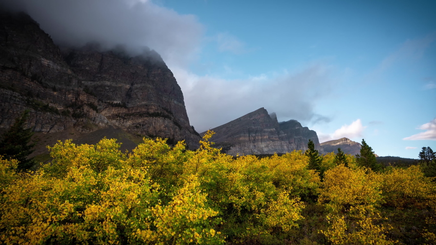 Time Lapse, Pristine Nature of Glacier National Park on Autumn Season, Clouds Above Peaks and Yellow Foliage, Montana USA