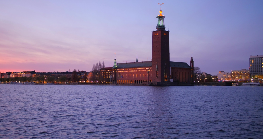 View Of Stockholm City Hall From Gamla Stan Across Riddarfjarden In Stockholm, Sweden At Sunset. wide, slider shot 4k