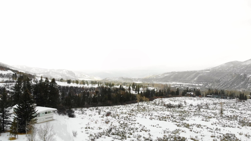 Winterscape Rocky Mountains Valley With Pine Trees And Snow-Covered Field Near Estes Park, Colorado USA. 4K Drone. Camera Moving Forwards.