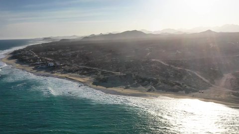 Fast orbitting drone video of blue waves and surging surf breaking along the beaches of the East Cape's turqouoise coast in the Sea of Cortez in Baja California Sur state of Mexico near Pacific Ocean
