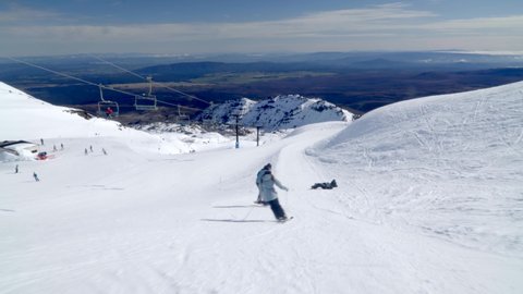 Alpine skiing and snowboarding on gentle slope at Mount Ruapehu, ski resort