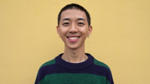 Happy young Asian teenager smiling in front of camera 