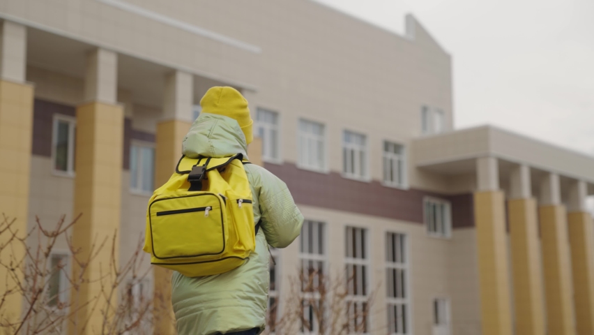 a small child with backpack goes to school, a kid with a school bag rushes to class, a happy girl, a first-grade student, schoolgirl of an educational institution, children's time to learn new things. Royalty-Free Stock Footage #1083355660
