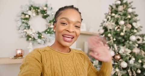 POV of happy African American woman with decorated Christmas tree with lights video chatting online and greeting friends and relatives with xmas. Xmas eve concept