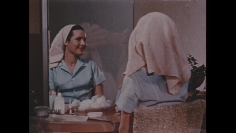 1950s: Woman scrubs back with bath brush. Elderly woman in evening gown descends staircase. Woman washes and styles her hair. Woman looks at her reflection in mirror.