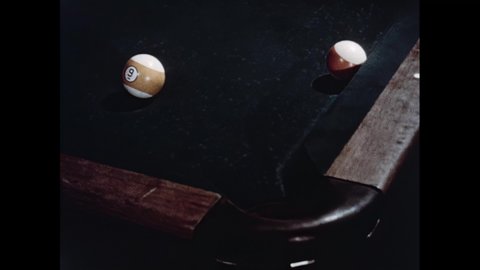 1950s: Men play billiards in pool hall. Hands rub chalk on pool cue. Pool cue strikes cue ball. Pool balls become snooker balls and form hexagon.