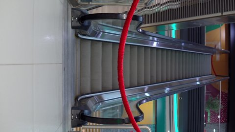 Fenced escalator with red tape in a shopping center. The passage to the automatic staircase is blocked. City lockdown 4k