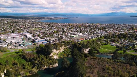 Taupo, beautiful New Zealand town on big lake during sunny day. Aerial panoramic cityscape