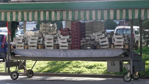 Market wooden and plastic crates on a metallic trolley with valence fabric roof