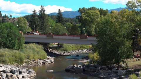 Wide shot of cars crossing bridge in Pagosa Springs during sunny day,Colorado