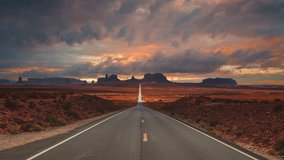 Scenic and cinematic golden red cloud sunset time-lapse at the iconic Forrest Gump spot road at the Monument Valley tea kettle rocks landmarks in Utah, Arizona, America USA. Cinemagraph seamless video - Powered by Shutterstock - Get 15% off with code: PIKWIZARD15