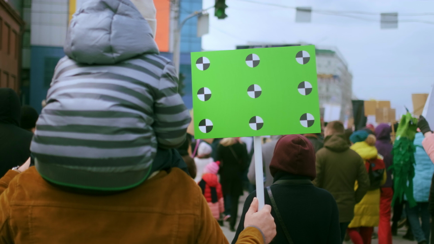 Father and son on political picket with empty banner, blank placard. Green screen rally poster with tracking points. Family of opposition protest activists. Mock up space, chroma key place for text.