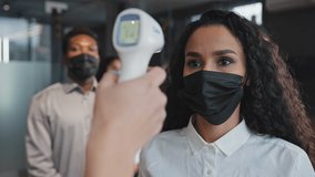 Close-up young hispanic girl standing office in mask get health checked measure temperature with electronic contactless thermometer employee safety indoor colleagues wait in queue coronavirus epidemic - Powered by Shutterstock - Get 15% off with code: PIKWIZARD15