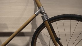 This panning video shows a close up view of a vintage 1930s bicycle hanging on a wall.