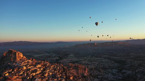 4k cappadocia and uchisar castle and balloons flying in the sky with aerial drone at sunrise