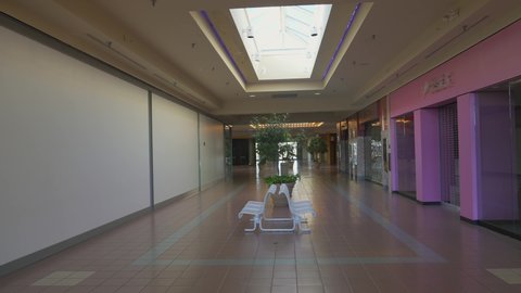 Indianapolis, IN USA - November 7 2021: This panning video shows an abandoned and eerie empty shopping mall interior.