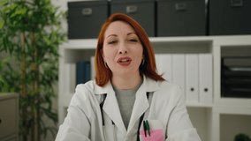 Young redhead woman wearing doctor uniform speaking at clinic - Powered by Shutterstock - Get 15% off with code: PIKWIZARD15