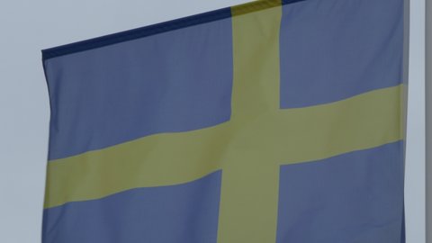 Ungraded: National flag of Sweden on the flagpole. Swedish official flag waving in the wind. Ungraded H.264 from camera without re-encoding.