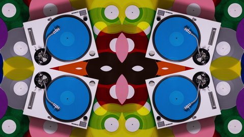 Overhead spinning shot of DJ turntables with different coloured records on the floor made into abstract mirrored pattern