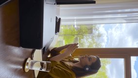 Vertical video young lady in headset sit at workplace speak talk before desktop pc screen present idea at corporate web conference. Confident female in earphones negotiate with business partner online - Powered by Shutterstock - Get 15% off with code: PIKWIZARD15