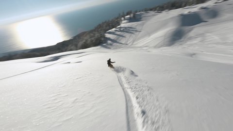 Aerial view athlete freeride snowboard on fresh snow slope Mamdziskha mountain sports FPV drone Abkhazia. Active male enjoy extreme leisure activity with Black Sea overview winter nature landscape
