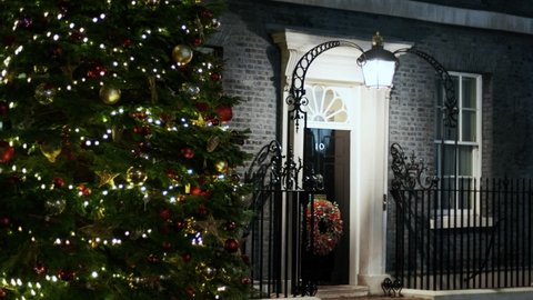 LONDON, DEC 2021 - Beautiful night rack focus shot of the Christmas tree and front door wreath decoration at 10 Downing Street, London, UK
