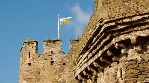The Welsh flag flies at Conwy Castle, in North Wales, UK, built by Edward I, during his conquest of Wales, between 1283 and 1289
