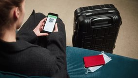 Woman tourist holding QR code on phone, sitting in airport terminal. Vaccination passport control, scanning digital health passport on phone, European coronavirus requirements for traveling. - Powered by Shutterstock - Get 15% off with code: PIKWIZARD15