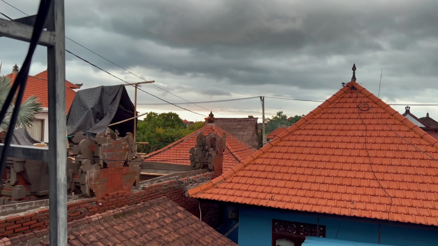 Dark strom clouds above orange roofs of village 4k
