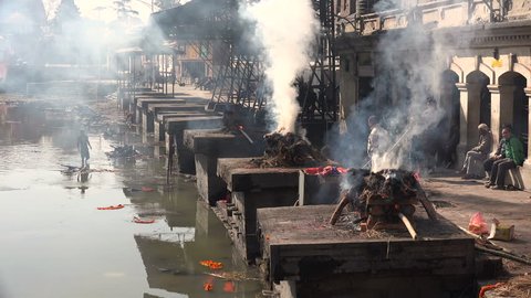 KATHMANDU, NEPAL - 5 JANUARY 2015: Workers burn the remains of recently passed away people at the cremation ghats in the Pashupatinath temple complex in Kathmandu.