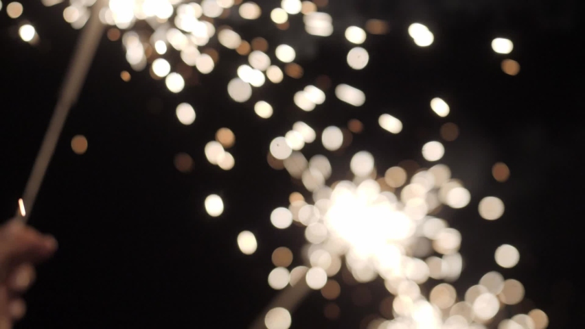 Celebrating event with bright sparklers fireworks in the people hands glowing in the night super slow motion close-up shot. Birthday or new year eve night party. Happy holiday celebration. | Shutterstock HD Video #1083421810