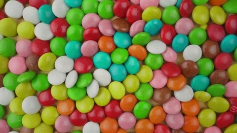 Background of multi colored sweet candy assorted on table or plate surface top view. Caramel and chocolate food for children and baby.
