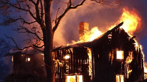 Burning wood house at night