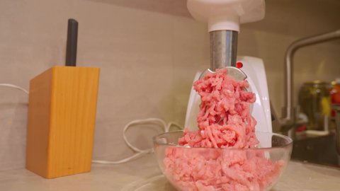 Meat grinder. Making homemade raw minced meat at kitchen.