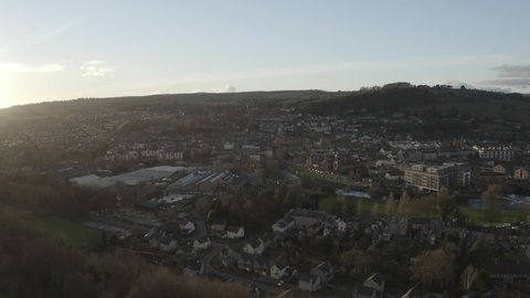 Aerial footage of large town at sunset with nearby fell (Kendal UK).