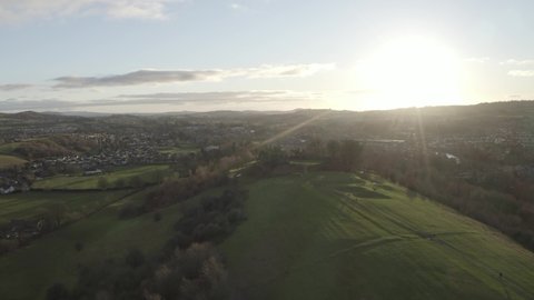 Aerial footage of large town at sunset with nearby fell (Kendal UK).