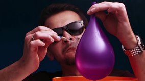 A European man in sunglasses and a cigarette in his mouth burst a purple ball with a dart in slow motion. - Powered by Shutterstock - Get 15% off with code: PIKWIZARD15